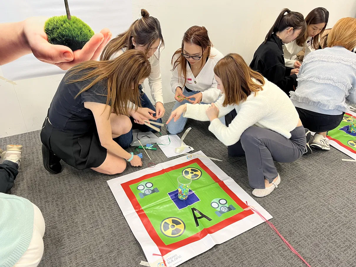 Corporate team strategizing for the 24 Game challenge during Steam Building VR Team Building 2.0 workshop.