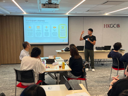 Corporate professionals collaborating on laptops during an AI team building and video creation workshop in Hong Kong.