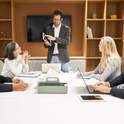 A person standing in front of 2 clients giving consulting
