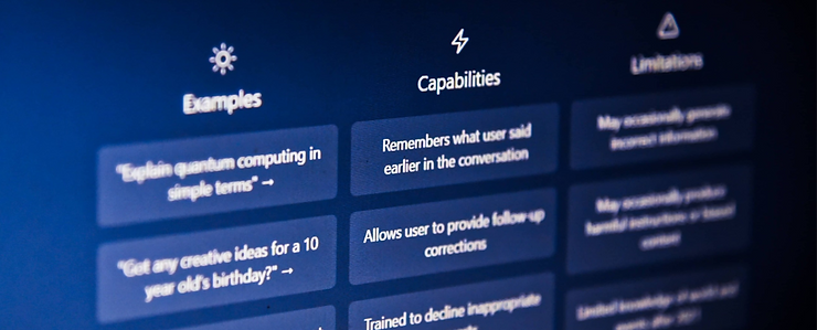 The ChatGPT website homepage on a computer screen, shot from a slight angle to the text. The website is dark blue, and the text in white has 9 buttons explaining ChatGPT capabilities, limitations, and offering examples.