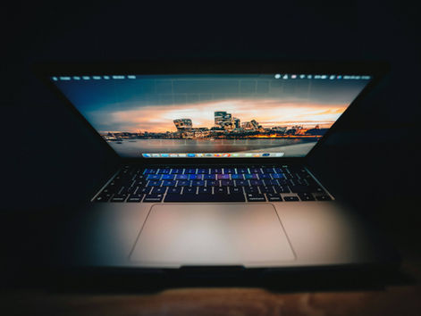 A laptop opening in the dark with a cityscape background (decoration)