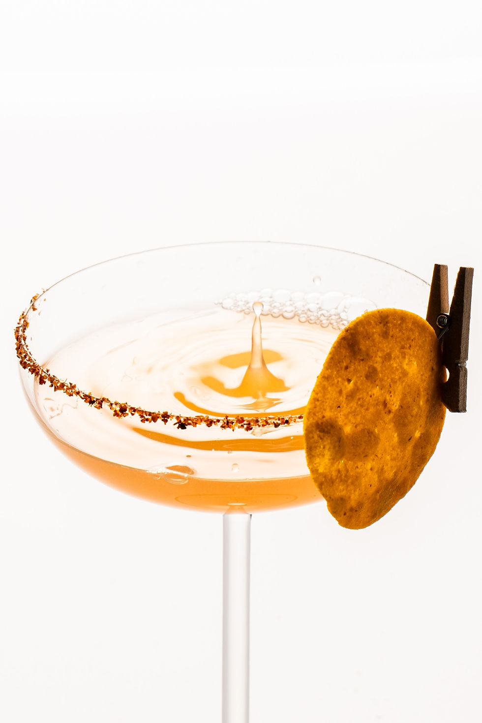Close-up of a cocktail splash with a spiced rim detail.