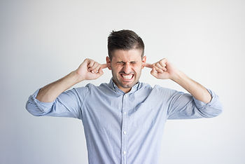 Homme souffrant d'acouphènes se bouchant les oreilles — sophrologie Paris et Cannes