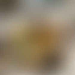 A bright, clean scene with a white background. A glass spray bottle filled with homemade scented vinegar (with citrus peels and herbs inside) is placed on a light wooden surface. Beside it, a small bowl of baking soda, a sliced lemon, sprigs of fresh rosemary, and a soft cotton cloth.