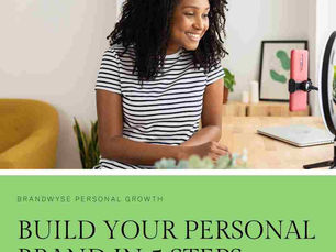 a woman sitting at her desk, modern bright setting with a text overlay saying Build Your Brand in 5 Steps
