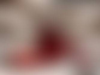 A small amber glass bottle filled with translucent ruby-red cranberry syrup, placed on softly rumpled off-white linen,