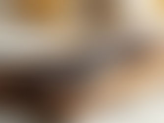 close up of vanilla pods lying on a wooden cutting board placed on a light marble kitchen top