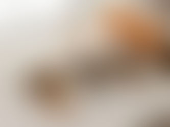 A minimal, softly lit flat-lay on a neutral linen surface. Several small muslin drawstring bags filled with dried orange peel, cloves and cinnamon, arranged neatly with a subtle handcrafted feel. A few pieces of dried peel, whole cloves and cinnamon sticks were scattered naturally around the bags. Unwaxed oranges and a small wooden bowl.