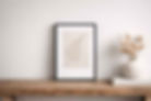 framed Botanical Paper Mâché Imprints standing on a rustic wood shelf next to a vase