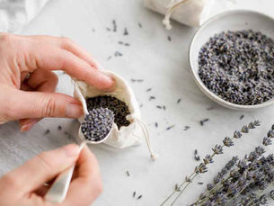 Hand die gedroogde lavendel in geurzakje lepelt