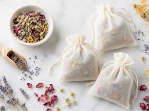 Flat lay of herbal bath sachets with dried lavender, chamomile, rose petals, calendula and citrus peel.