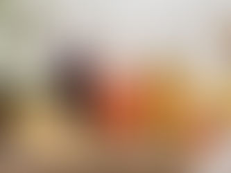 Drie glazen flessen met zelfgemaakte siropen van vlierbes, kweepeer en kruiden op een lichte houten tafel met vers fruit, citroen en kruiden.