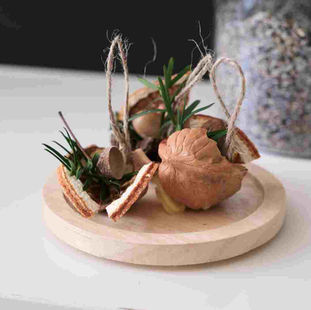 3 walnut firestarters decorated with pine, dried orange, acorns and beeswax
