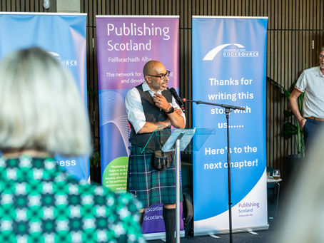 BookSource MD, Davinder Bedi dressed in a kilt speaking in front of a lectern.