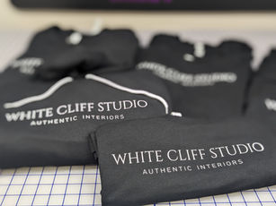 group of folded sweatshirts with an elegant business logo printed on the front chest area.