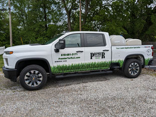 A work truck for a small business lawn company featuring bright die cut grass along the bottom and custom vinyl lettering on the sides and back.