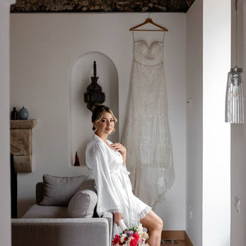 Bride in robe with wedding dress behind her during Amalfi Coast elopement
