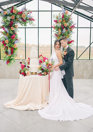 Wedding ceremony flowers thoughtfully repurposed for the cake table décor during a luxury wedding reception photographed by Baskin Creative Co., a Canadian wedding photographer.
