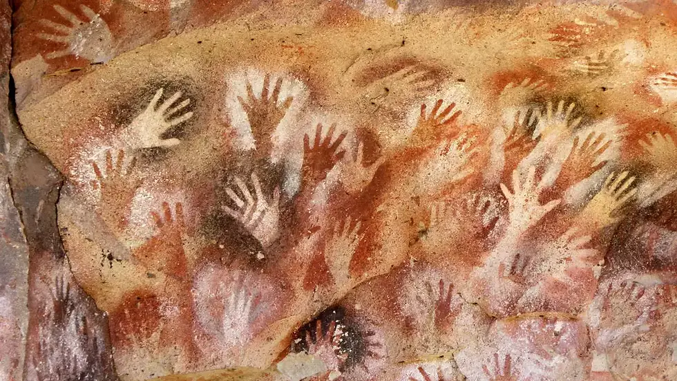a bunch of hand prints on a cave wall