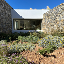Maison moderne avec murs en pierre et jardin ornemental, EGEO Paros.