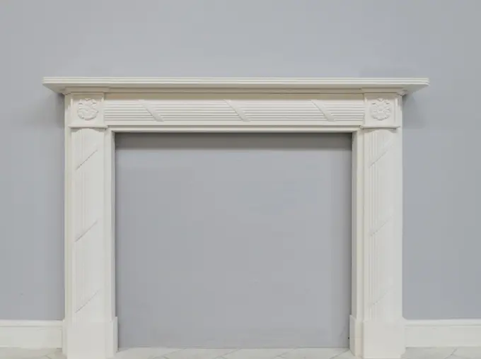 Holyrood fireplace surround in Aegean limestone with roses in the corners and ridges on the upright legs