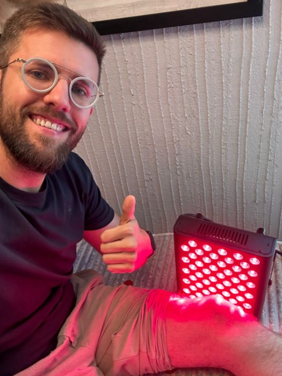 Dr. Bantsich zeigt Daumen nach oben neben Rotlichttherapiegerät