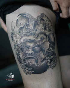 Detailed black and gray tattoo of a face on a thigh; art and design.