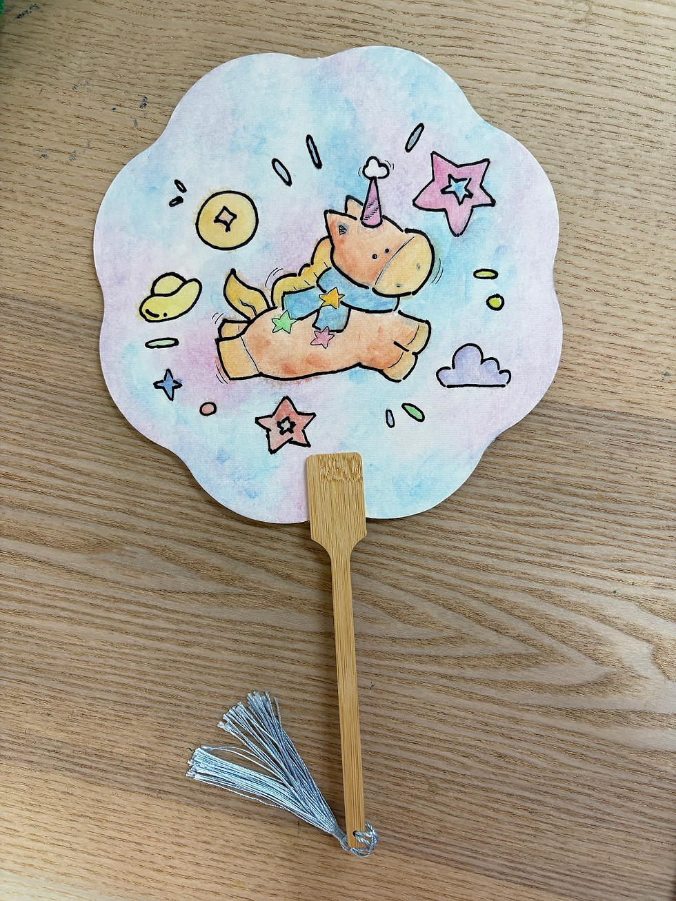 A hand fan with the design of a unicorn with stars, ingots and coins in the background. VIAC