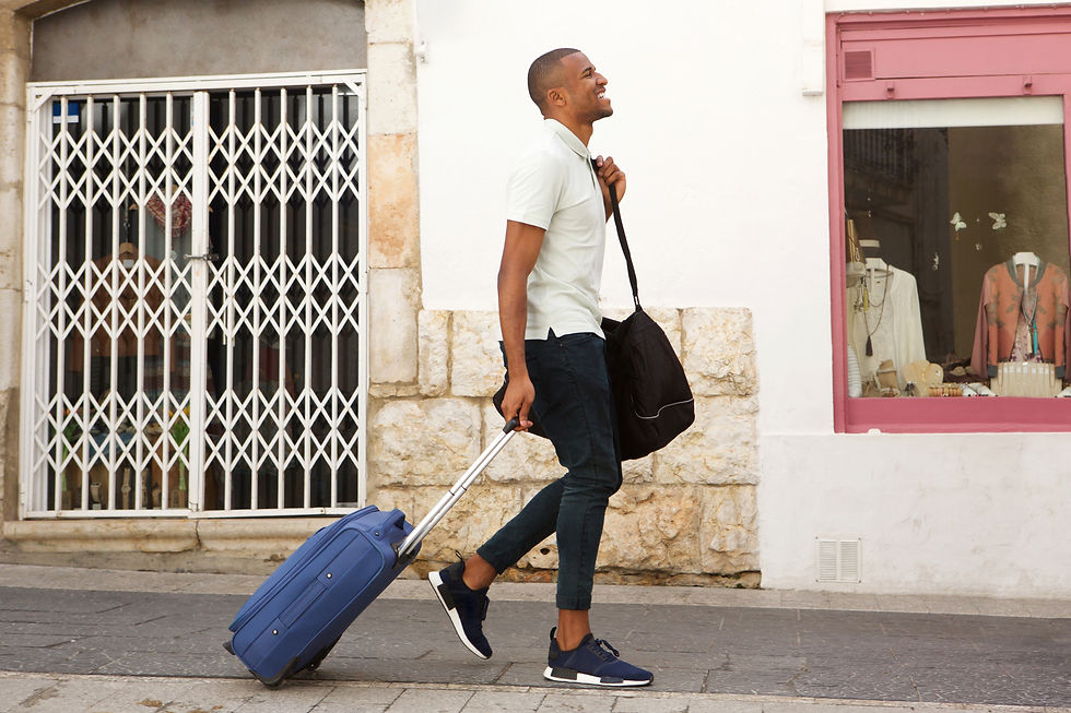 Happy man with suitcase walking down street