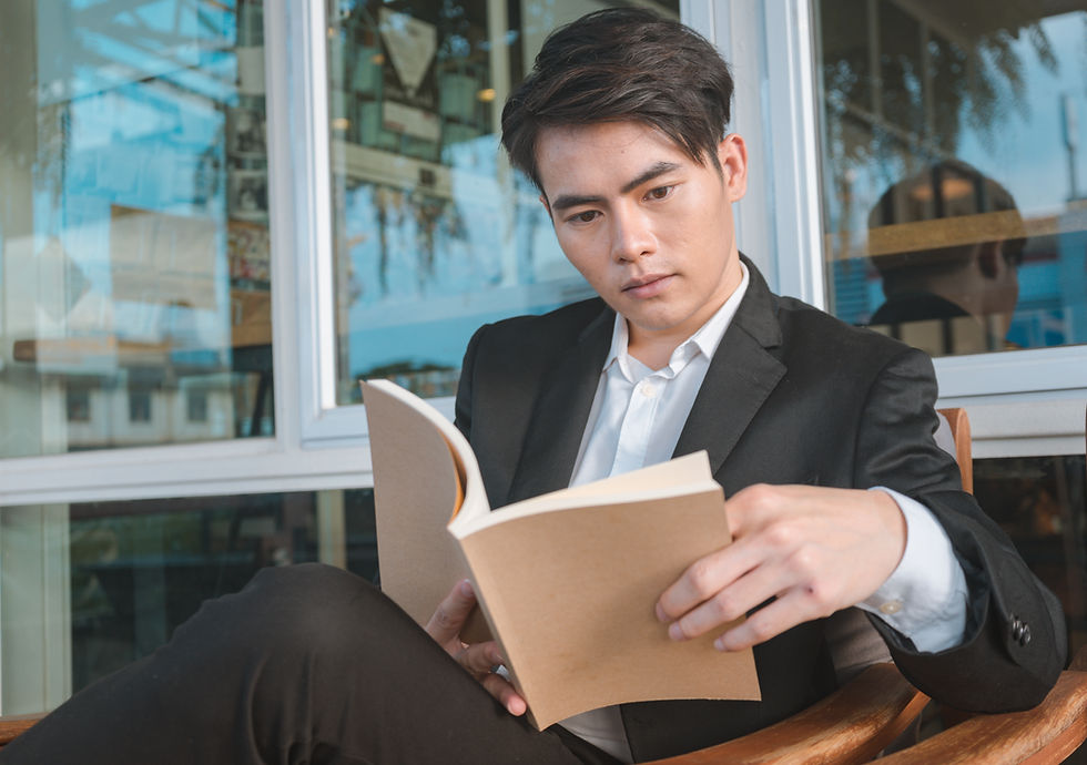Man in business attire reading a book