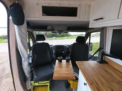 The cab of the van with two swivel seats and table holding mugs of tea