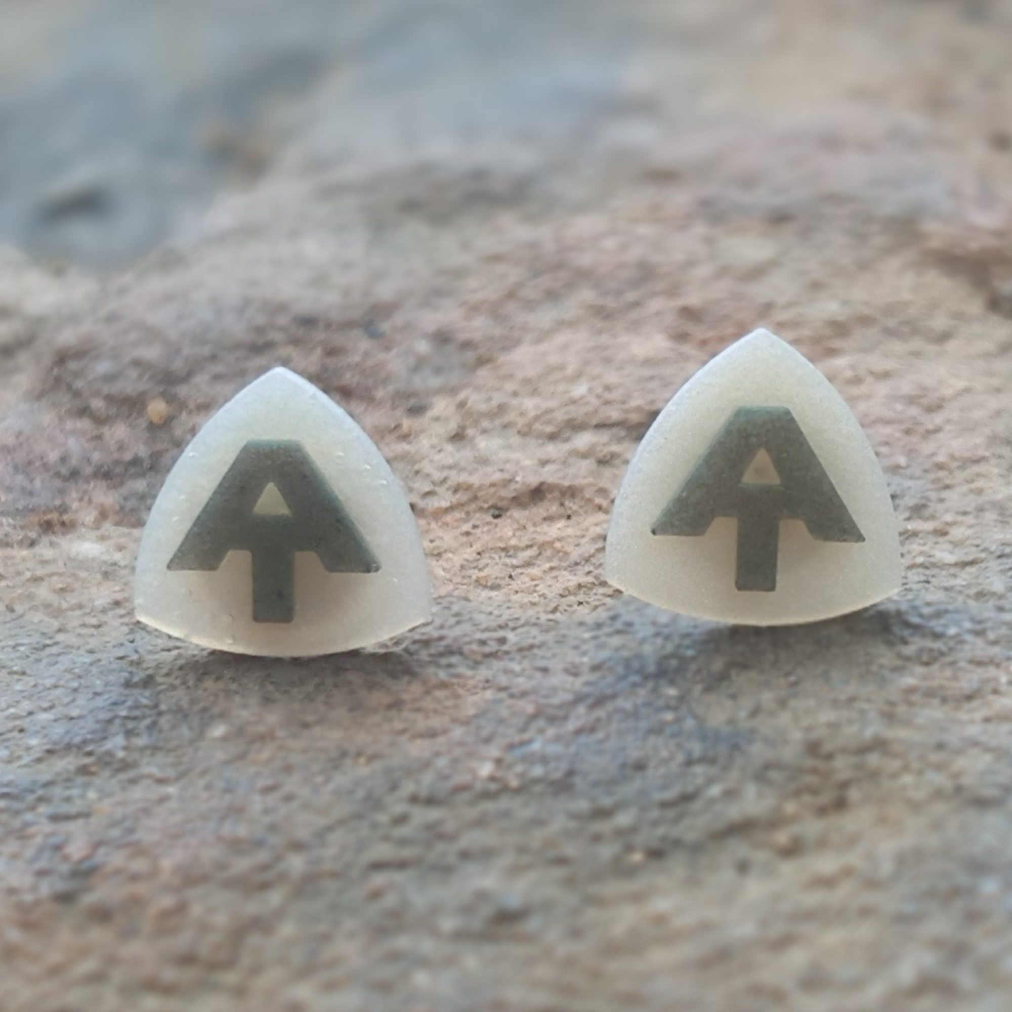 Hang tag stud earrings displayed on rocks