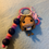 Thumbnail: Funko Pop keychain, female character with brown hair, pink and purple beads.