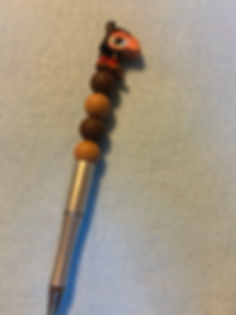 Makeup brush with gradient brown and tan beads stacked on handle.