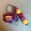 Thumbnail: Purple monster character keychain with yellow teeth and colorful beads