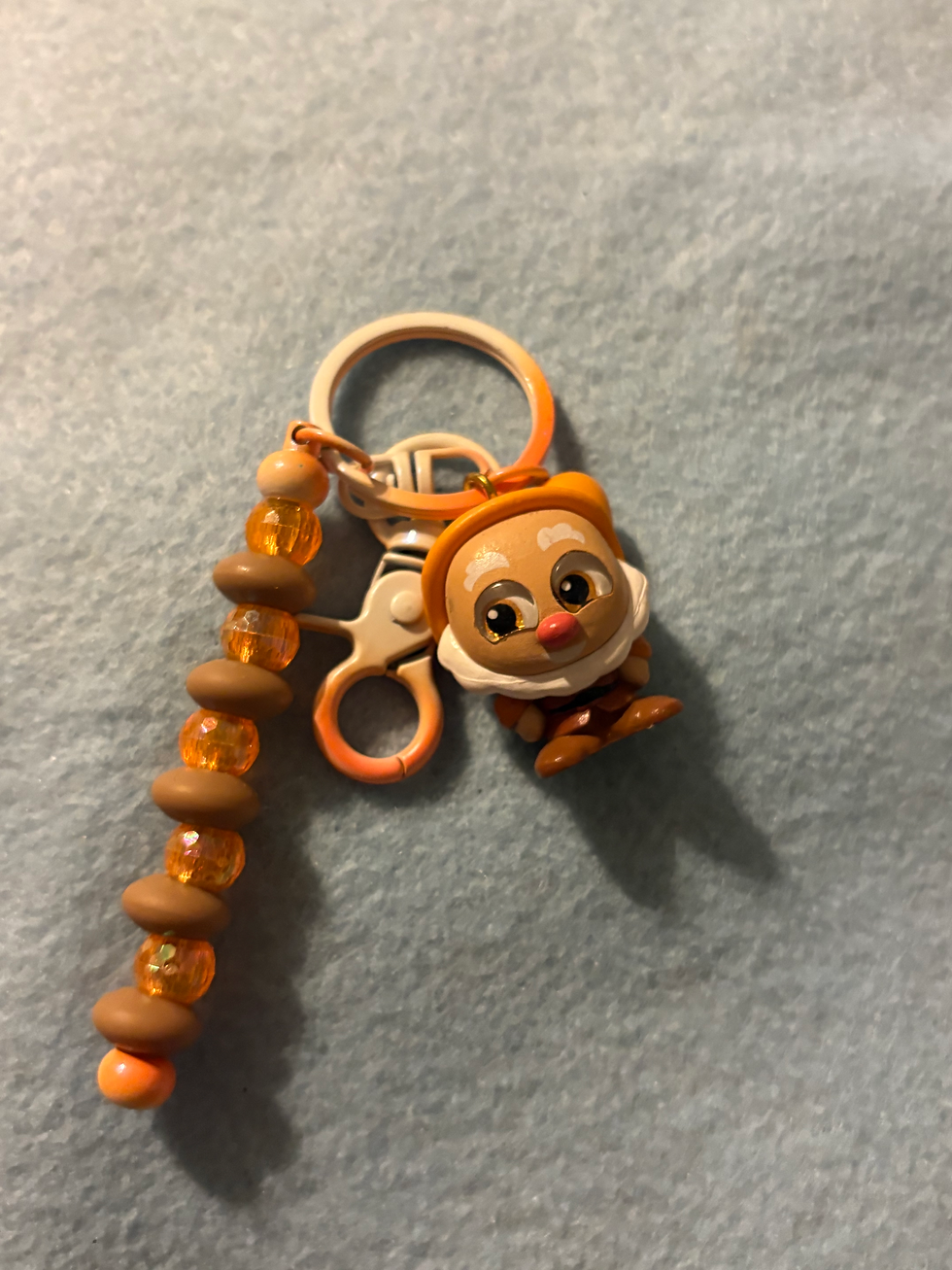 Thumbnail: Keychain with cartoon character charm, beaded strap, brown and orange beads.
