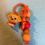 Thumbnail: Orange keychain with cute brown puppy figure and colorful orange, red beads.