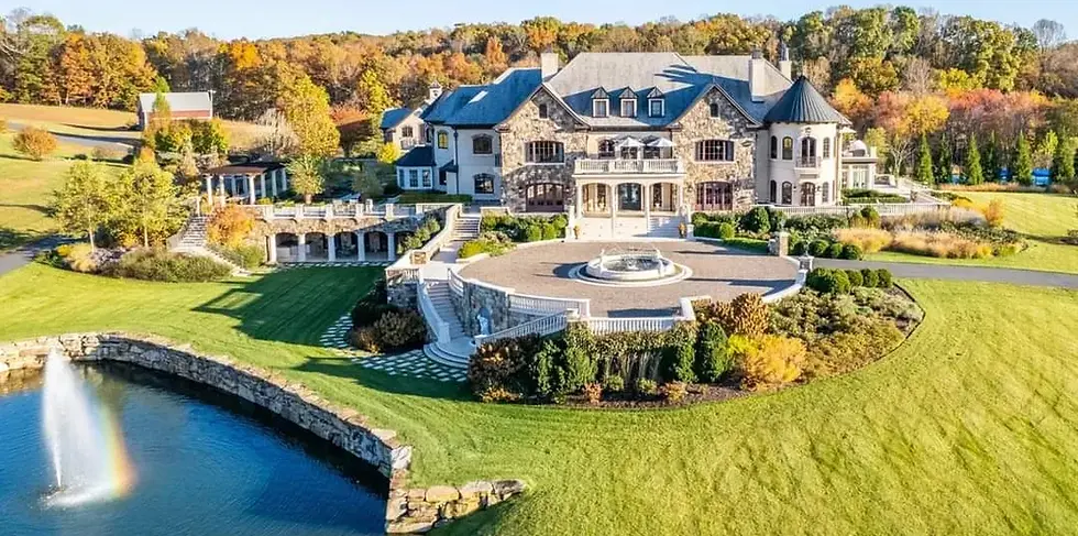 Castlebrook Estate luxury wedding venue in Aroda, Virginia featuring a grand European-inspired stone mansion, sweeping manicured lawns, elegant terraces, and a private pond with fountain set against the Blue Ridge Mountain countryside during autumn.