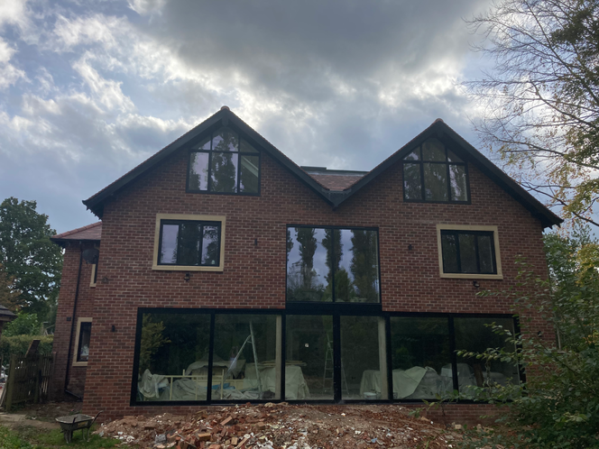 three storey extension extending around the rear of a large house
