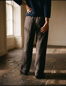 A person standing with a hand on the hip and back of the thigh