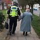 police officer holding hands with elderly woman.webp