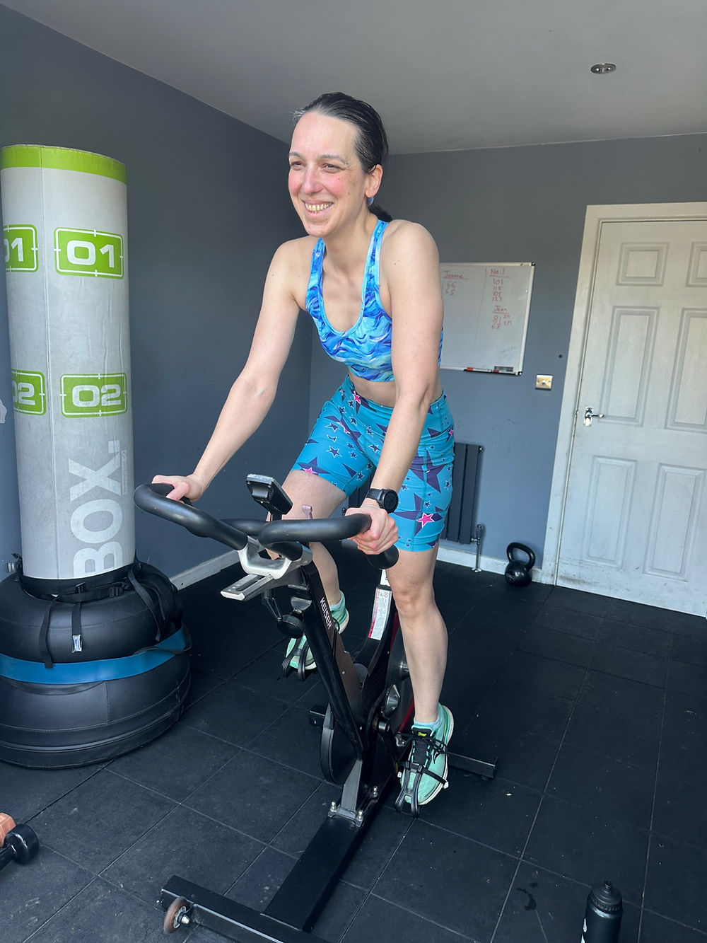 Smiling woman exercising on a spin bike