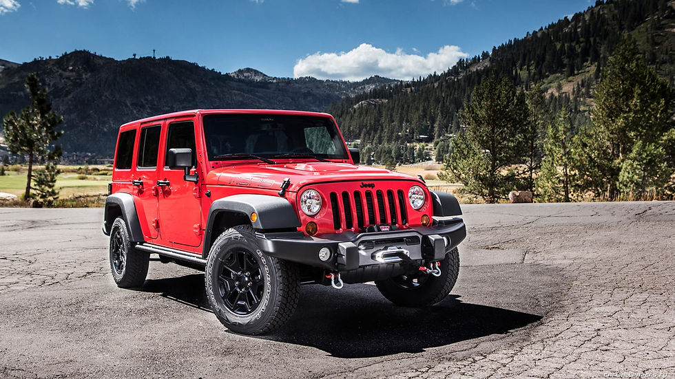 Red four-door Jeep Wrangler parked in a mountain landscape