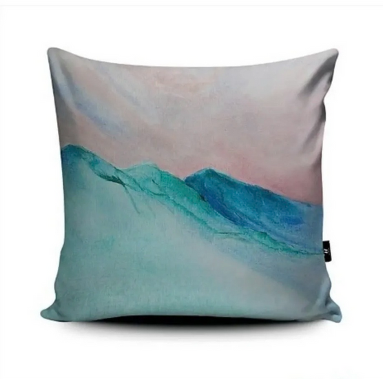 Cushion printed with design that suggests cold mountain landscape - pale aquamarine foreground goes into darker blue peaks with a light skyline