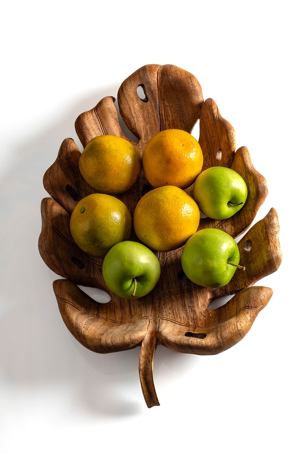 Miniatura: charola decorativa hecha a mano en madera de parota con forma de hoja de monstera sugerencia de uso con naranjas