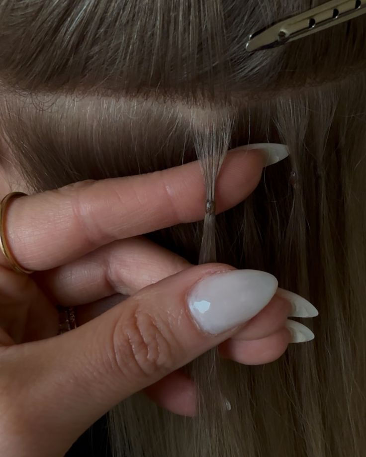 A stylist showing a close-up of hair extensions