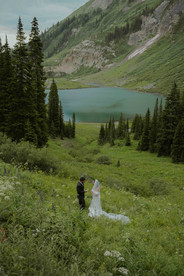 bride and groom eloping in crested butte above an alpine lake