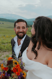groom looking at his bride eloping in crested butte wildflowers