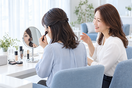 鏡を見ながら自分でメイクを練習する女性のイメージ