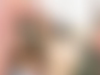 Young black father with his young daughter walking down a street laughing and smiling as if having a fun conversation. They are wearing wintery clothing and he is carrying a brown paper sack full of groceries as if they are on their way home from the supermarket seen in the background